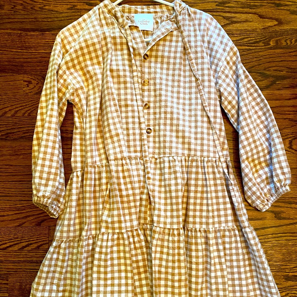 Tan gingham dress. Long sleeves, pockets, and functional buttons.